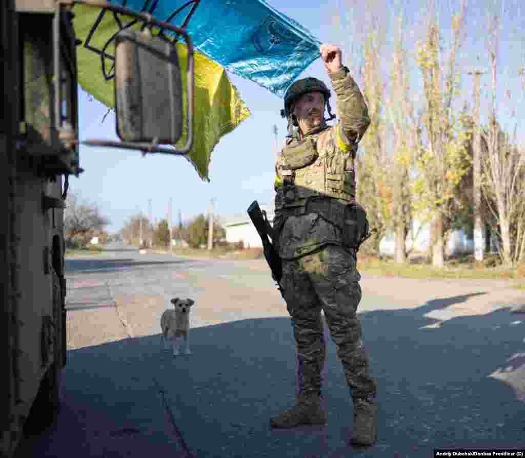 Український боєць показує збережений у боях прапор України, чиї кольори виблискують під промінням сонця, яке вже починає сідати над звільненою від російських окупантів Снігурівкою. Місто, розташоване на стратегічній висоті на самому півдні Миколаївщини і за 50 кілометрів від Херсону, було окупованим з початку березня 2022 року