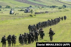 Іспанські, німецькі та нідерландські військові поруч з військовими гелікоптерами на полігоні Богата, Румунія, 14 травня 2024 року