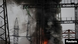им і вогонь біля високовольтної лінії на місці російського ракетного удару під час атаки України поблизу Харкова, 22 березня 2024 року
