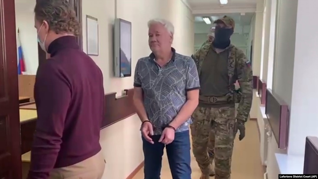 Robert Shonov, a former worker at the now-closed U.S. Consulate in Vladivostok, is led away by Russian security personnel in May.