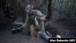 Український військовослужбовець бригади «Азов» готує снаряди для гаубиці OTO Melara Mod 56 на позиції на Кремінському напрямку, Донецька область, Україна, 11 квітня 2024 року