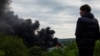 Підліток дивиться на дим, який піднімається після російського ракетного удару в Харкові, 17 травня 2024 року