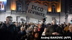 A woman holds a placard reading "Sorry children" as opposition supporters take part in a demonstration outside the Electoral Committee building in Belgrade on December 18.
