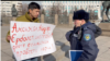 Республика алаңына пикетке шыққан Темірлан Еңсебекке (сол жақта) акция заңсыз екенін айтып тұрған полиция қызметкері. Алматы, 9 ақпан, 2024 жыл.