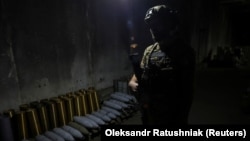 Український військовослужбовець стоїть в укритті біля артилерійських снарядів на передовій в Запорізькій області, 13 вересня 2023 року