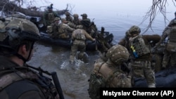 Українські військовослужбовці сідають на катери біля берега Дніпра на Херсонщині, 15 жовтня 2023 року
