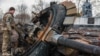Украинский военный осматривает оторванную башню российского танка, архивное фото