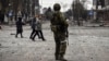Люди проходять повз російського солдата в центрі Маріуполя, 12 квітня 2022 року (ілюстраційне фото)