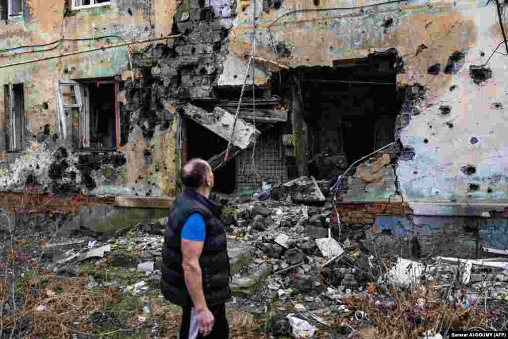 60-річний Андрій Плешан дивиться на зруйнований будинок, неподалік якого він живе у підвалі. Ізюм, Харківщина, 2 січня 2022 року У тому підвалі, за довгі місяці окупації Ізюма російськими військами, мешкало до 60-ти людей. Серед них було і двомісячне немовля - дівчинка Ніка. 