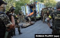 Украинские военные спасают раненого бойца во время боев под Иловайском, 10 августа 2014