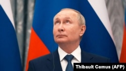 რუსეთის პრეზიდენტი, ვლადიმირ პუტინი რუსული დროშის ფონზე. 