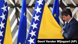 Član protokola namješta zastavu Bosne i Hercegovine pored zastave EU u Briselu, juni 2022.