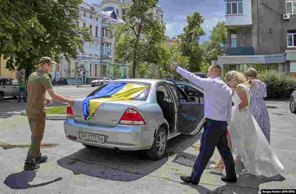 Військовослужбовець Нацгвардії Ігор та його наречена Кіра виходять із підвалу РАЦСу в Харкові 23 червня. Через загрозу обстрілів весілля у Харкові зараз часто проводяться у підземних приміщеннях.