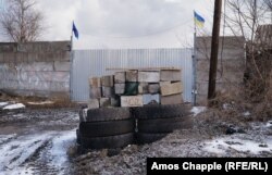 Імпровізована барикада з прапорами України та української армії, які майорять на одному зі службових входів на металургійний завод «Азовсталь», 6 лютого