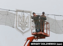Робітники встановлюють зображення Тризуба в Києві 2014 року
