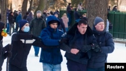 Manifestanți escortă un polițist dezarmat în Dniepropetrovsk, 26 ian. 2014.