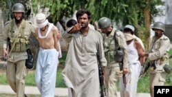 سربازان پاکستانی، چند تن از طلابی را که تسليم شده اند، با خود می برند.