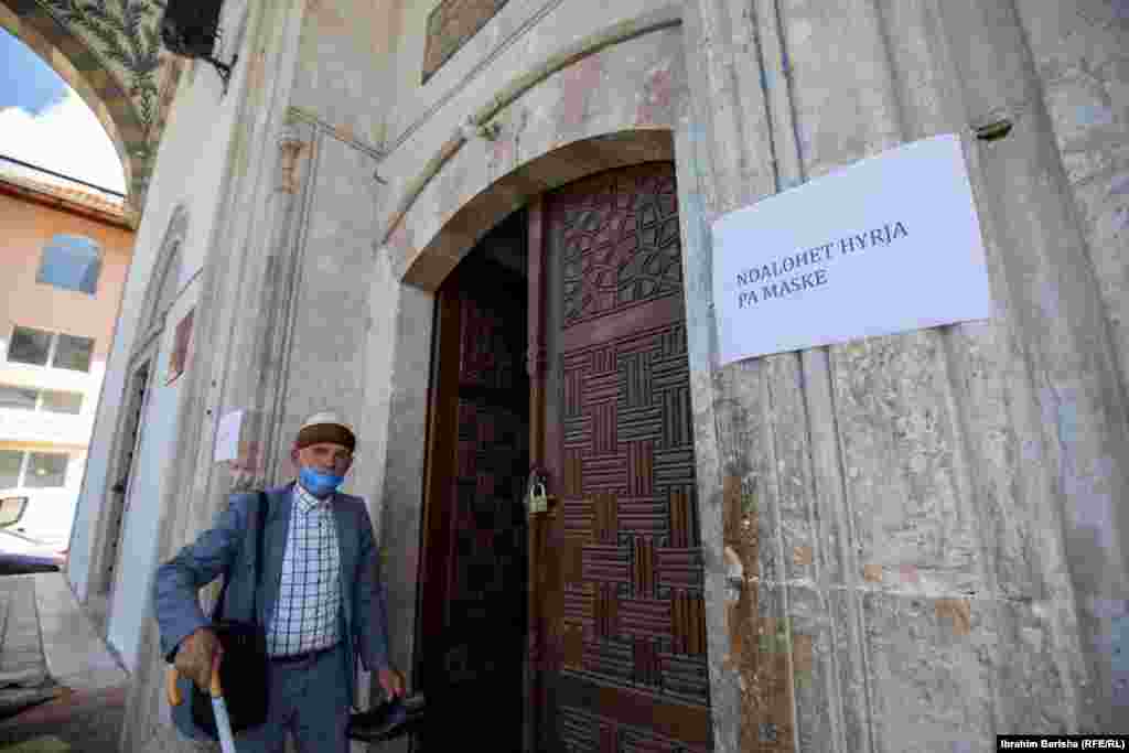 Літній чоловік заходить до мечеті в Приштині в Косові, на якій висить оголошення, що забороняє вхід тим, хто не носить захисні маски &ndash; але не уточнює, як саме ту маску вдягати