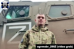 Російський солдат з 200-ї бригади записує звернення до рідних на тлі бронеавтомобіля «Спартак» у тій самій кольоровій гамі, що й машини, що прибули на станцію Озерище під Мінськом. Скріншот з відео, опублікованого на Телеграм-каналі «Гвардійська 200-та бригада ЛенВО»