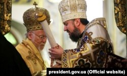Глава Православної церкви України митрополит Епіфаній (праворуч) в момент отримання від Вселенського патріарха Варфоломія томосу про автокефалію. Стамбул, 6 січня 2019 року