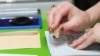 Armenia - An election official puts a stamp on a voter's passport in Yerevan, 6May2012.