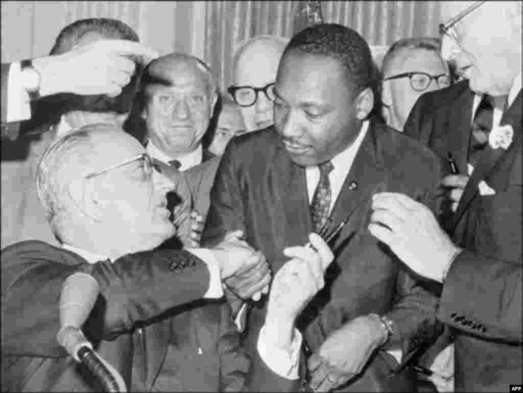 Američki predsjednik Lyndon B. Johnson potpisao je Zakon o građanskim slobodama i Zakon o glasanju, čime je zakonski zabranjena diskriminacija u školama, zapošljavanju i prilikom glasanja. na fotografiji: King se rukuje s&nbsp;Johnsonom, Washington, 3. juli 1964.