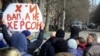 Жителі Херсона стоять перед російськими військами на вулиці під час мітингу проти окупації міста, 14 березня 2022 року
