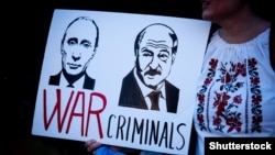Плакат із зображенням Володимира Путіна та Олександра Лукашенка з написом «Воєнні злочинці» під час акції протесту проти російського вторгнення в Україну, Лондон, 26 березня 2022 року