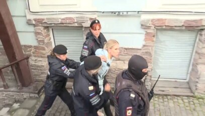 Maskirani policajci privode rusku opozicionarku