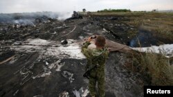 Ресейшіл қарулы сепаратист Украинада құлаған Boeing 777 ұшағының қалдығын суретке түсіріп жүр. Донецк, 17 шілде 2014 жыл.