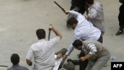 نیروهای لباس شخصی در حال زدن یکی از معترضان