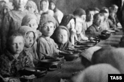 Годування дітей в їдальні в Покровську (нині місто Енгельс) Самарської області. Місто Покровськ постало на місці Покровської слободи, яку заснували українські чумаками в 1747 році. Поволзькі німці називали місто Kosakenstadt