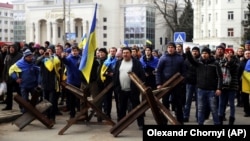 Люди стоять перед військовими Росії під час мітингу проти російської окупації. Херсон, 7 березня 2022 року