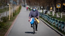 Жінка на велосипеді їде алеєю біля Машинобудівного заводу