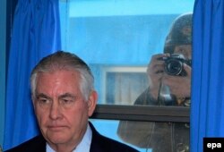 Военнослужащий Северной Кореи фотографирует государственного секретаря США Рекса Тиллерсона из окна во время его визита в пограничную «мирную» деревню Пханмунджом на межкорейской границе. 17 марта 2017 года.