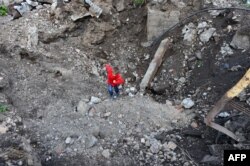 Дитина вилазить з великої воронки. Первомайськ, Луганська область, вересень 2014 року