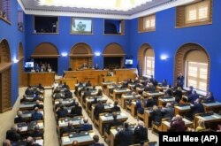 Президент України Володимир Зеленський (на екрані) під час звернення через відеозв'язок до парламенту Естонії. Таллінн, 13 квітня 2022 року