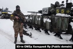 Український військовий біля колони військової техніки 200-ї мотострілецької бригади, знищеної під Харковом на початку березня 2022 року