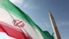 An Iranian flag fluttering at an undisclosed location in the Islamic republic next to a surface-to-surface Qiam-1 (Rising) missile which was test fired a day before Iran was due to launch its Russian-built first nuclear power plant