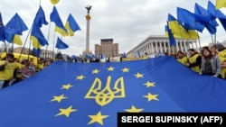 Архівне фото. Молодь тримає прапор Євросоюзу з гербом України на майдані Незалежності в Києві, 30 жовтня 2013 року