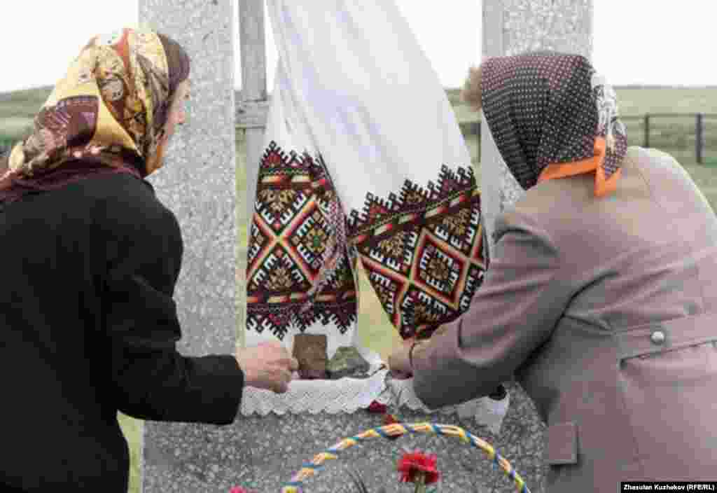 Әскери тұтқындар мен қуғын-сүргін құрбандарының Спасск зиратында украиндарға арналған ескерткіш алдында тұрған әйелдер. Қарағанды облысы Спасск ауылы, 31 мамыр, 2011 жыл.