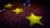 Перехожі біля лоґо ЄС поблизу виборчого штабу німецьких християнських демократів в Мюнстері, Німеччина