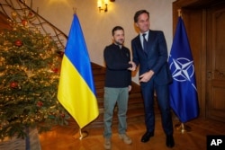 Генеральный секретарь НАТО Марк Рютте (справа) пожимает руку президенту Украины Владимиру Зеленскому перед встречей в Брюсселе, 18 декабря 2024 года