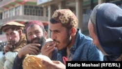 د افغانستان په خوست ولايت کې يو مزدور د کار په تمه ناست د غرمې ډوډۍ خوري (انځور له ارشیفه) 