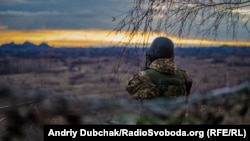 Архівне фото: український військовий біля Золотого-4, що було обстріляне і нині. Терикони вдалині – вже на окупованій території