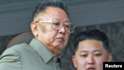 Ким Чен Ир мураскер уулу Ким Чен Ын менен аскерий парадды көрүү учурунда. 2010-жылдын 10-октябры.