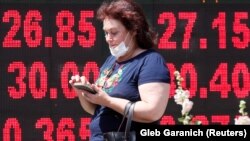 Жінка проходить повз табло з курсами валют, Київ, 2 липня 2020 року